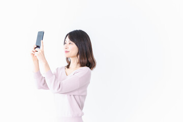 Fototapeta premium 笑顔でスマホ撮影をする若い女性