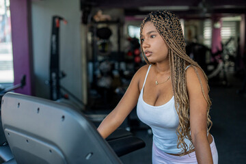 Young woman training on a treadmill in gym