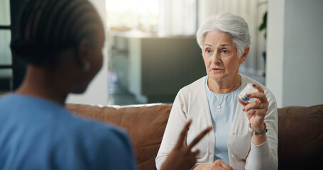 Fototapeta premium Medical, pills and question of old woman with nurse on sofa for help or home appointment. Consulting, healthcare or medication of senior person with caregiver in apartment for assisted living checkup