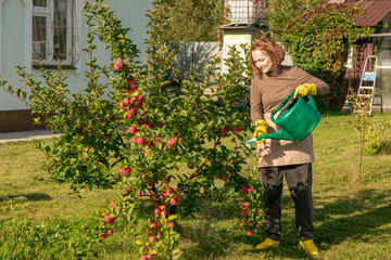 woman fertilizing apple tree