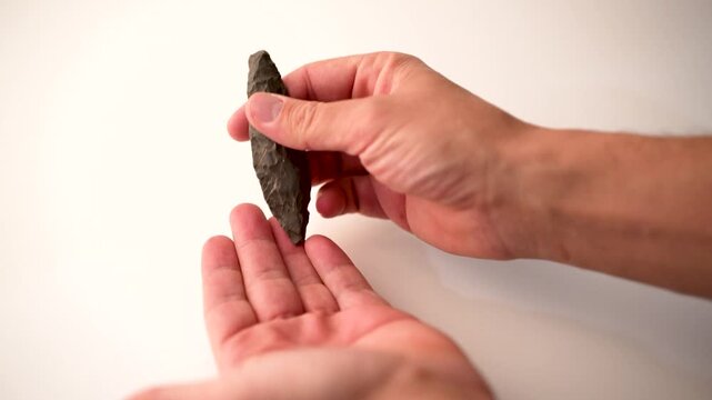 slow motion. Authentic Paleolithic Biface Spear Head from Algerian Desert Held in Hand