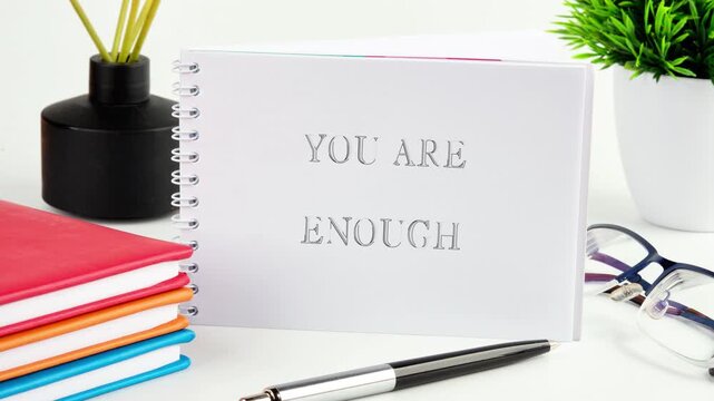 Creative expressions showcase the powerful phrase you are enough, surrounded by vibrant stationery and greenery, creating an uplifting atmosphere for self-reflection and motivation