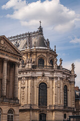 Fototapeta premium A beautiful wing from apalace in Paris, France, on a picturesque, cloudy blue sky.