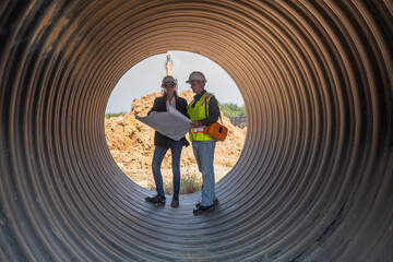 Engineer working Industrial pipeline system used for water supply or electrical cable protection large cylindrical pipes arranged in infrastructure underground utilities and public infrastructure.