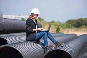 Engineer working Industrial pipeline system used for water supply or electrical cable protection large cylindrical pipes arranged in infrastructure underground utilities and public infrastructure.