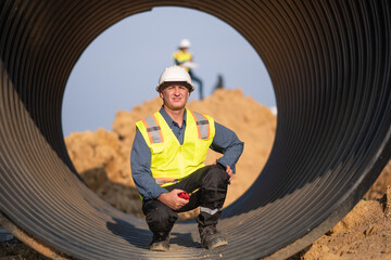 Engineer working Industrial pipeline system used for water supply or electrical cable protection large cylindrical pipes arranged in infrastructure underground utilities and public infrastructure.