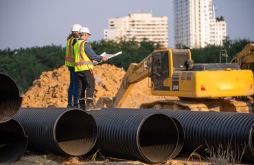 Engineer working Industrial pipeline system used for water supply or electrical cable protection large cylindrical pipes arranged in infrastructure underground utilities and public infrastructure.