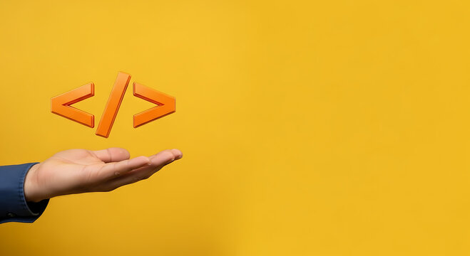 A hand holding a coding symbol on a yellow background with space for text