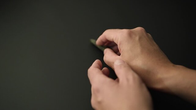 Authentic Paleolithic Biface Spear Head from Algerian Desert Held in Hand. slow motion video. black background. 4k at 50 fps