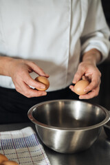 Experienced pastry chef expertly stirs eggs in metal bowl for baking dough