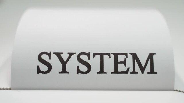 The word SYSTEM is printed in large black letters on white paper.