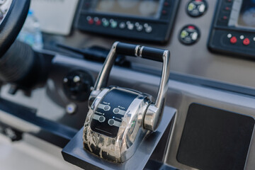 Boat throttle control lever with buttons and gauges in a modern marine dashboard, featuring a sleek...