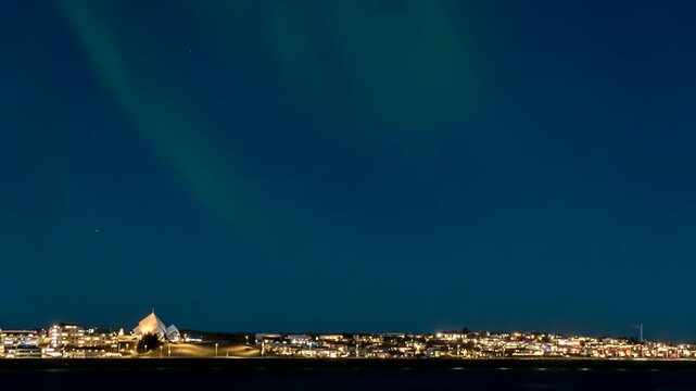 Green northern lights flashing over the city of Reykjavik, Iceland