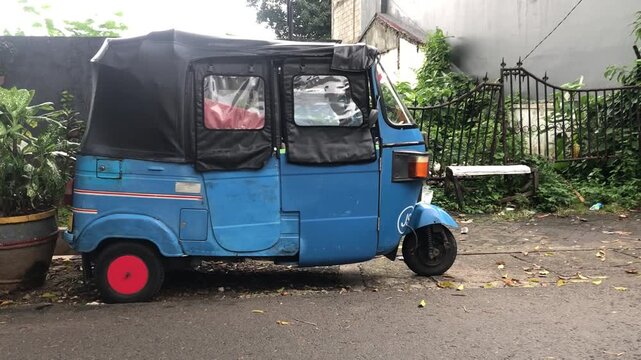 blue tuk tuk or bajaj vehicle on street.