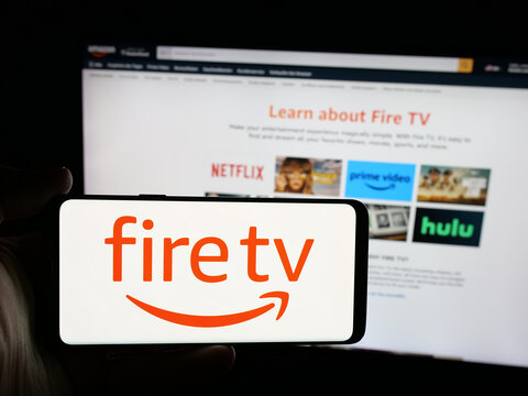 Stuttgart, Germany - 01-22-2026: Person holding smartphone with logo of digital media player Amazon Fire TV on screen in front of website. Focus on phone display.