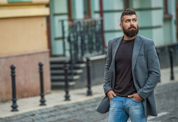 Bearded man in autumn jacket on street. Businessman has business style. Business man in urban city. Stylish businessman crossing street. Urban style. City street and stylish man, banner
