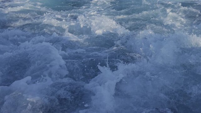 Detailed view of foamy blue ocean water in motion.