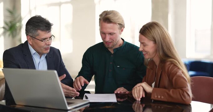 Happy couple signing mortgage contract or rental agreement, handshake with realtor or bank advisor, receiving keys, celebrating successful property buying. Real estate transaction, deal, homeownership