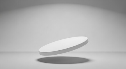 White circular platform floating in minimalist gray studio background