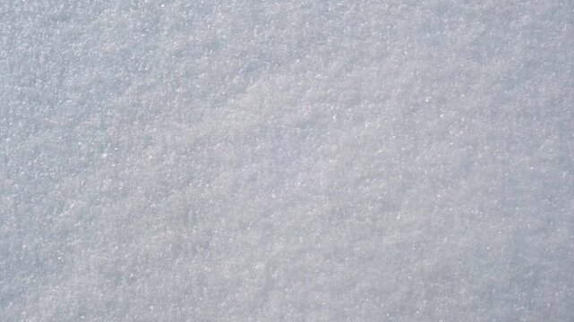 Close up of clean fresh white snow surface texture with glistening ice crystals in winter