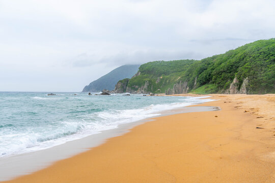 Beach on Sea of Japan coast at Primorsky krai (Primorye), with yellow sand and beautiful landscape popular among tourists.
