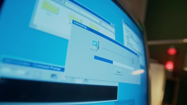 No people close-up of blinking screen of vintage desktop computer monitor, with program establishing dial-up internet connection, in study or living room at home