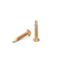 Pile of yellow zinc plated self-drilling screws isolated on white background.