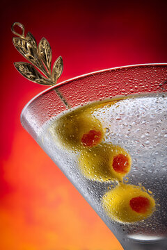 Copa de martini con aceitunas y adorno dorado fondo rojo, Bebida de lujo estilo elegante con fondo vibrante, Detalle de c&oacute;ctel para blog de estilo de vida premium