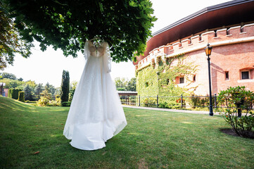 Naklejka premium Elegant Wedding Dress Hanging Outdoors