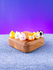 A close-up of a set of colorful, adorable animal interior figurines in kawaii style, placed on a wooden stage