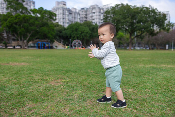 Baby clapping hands happily at park outdoors