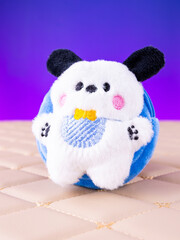 A close-up view of a soft, blue plush wallet featuring an adorable puppy design