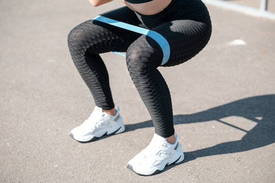 Woman Squatting With Resistance Band