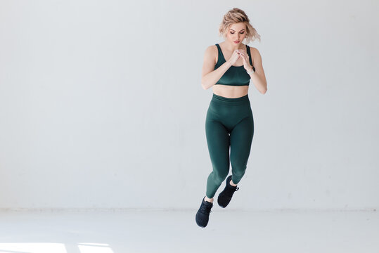 Fitness blonde girl in trending sport outfit training at loft studio