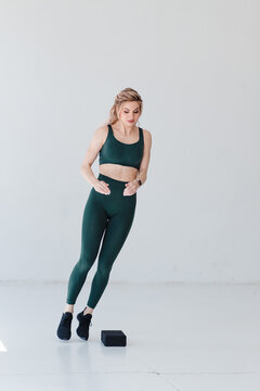 Fitness blonde girl in trending sport outfit training at loft studio
