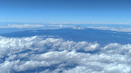 Breathtaking Aerial View of Snowcapped Mountain Range Emerging from Fluffy White Clouds Under Bright Blue Sky in Daytime Scenic Landscape