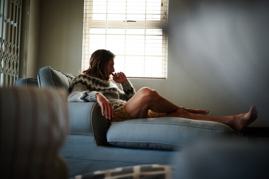 Thinking, uncertain and man on sofa with choice, problem solving and decision for mistake. Confused mindset, remember and male person in living room with doubt, questioning and regret in memory.