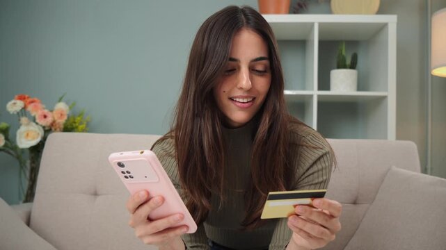 A woman engages in online shopping, using her smartphone to browse products while holding a credit card for secure transactions, showcasing convenience and modern purchasing methods.