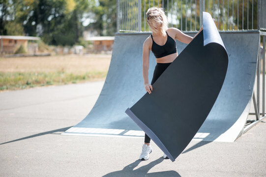 Woman With Yoga Mat At Skatepark