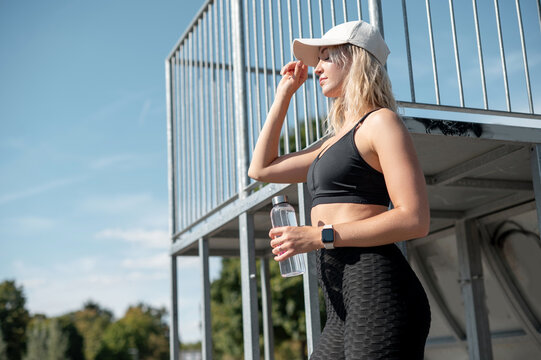 Woman in Sportswear Hydrating Outdoors