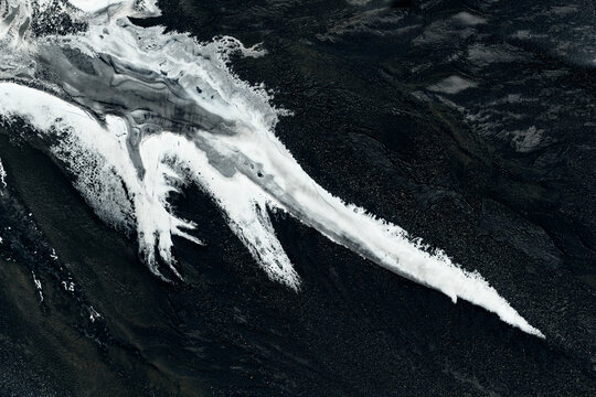 Braided glacier river flowing through black volcanic landscape