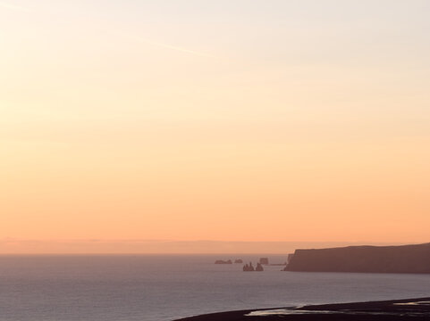 Dyrholaey and reynisdrangar sea stacks at sunset in iceland