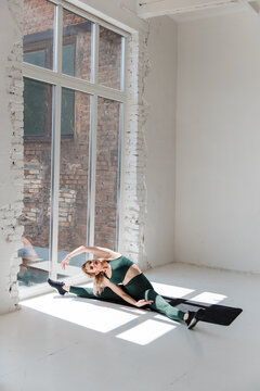 Fitness blonde girl in trending sport outfit training at loft studio