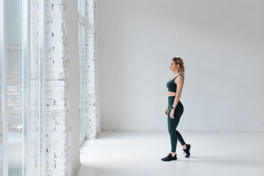 Confident active woman in sport clothing posing on camera