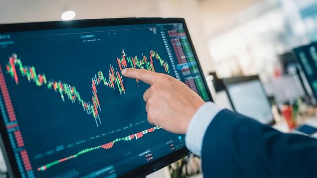 Close view of professional trader pointing at digital stock chart on large screen showing market movement analysis financial strategy investment decision and business confidence in modern workspace