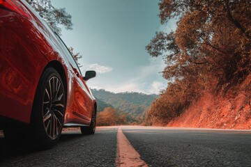 Red hatchback speeding along a forest road with motion blur