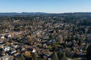 Fototapeta premium Aerial drone top down picture of a residential neighborhood in Beaverton, Oregon, showing rows of different houses, rooftops, parking areas, and local streets. Clean suburban real estate and housing 