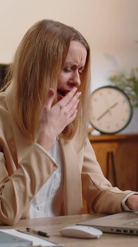 Bored sleepy businesswoman lady worker working on laptop computer, yawning, lying on hands falling asleep at office. Exhausted tired freelancer workaholic young woman. Employment, occupation, workless