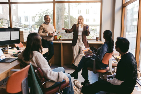 Female manager talking with colleagues during meeting in office