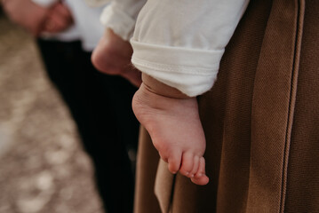 Feet of a small child dressed in white during a baptism